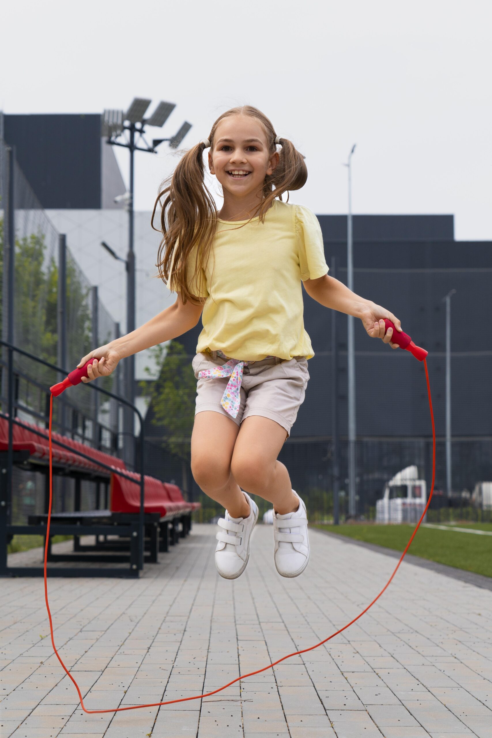 full shot smiley girl jumping red rope (1)